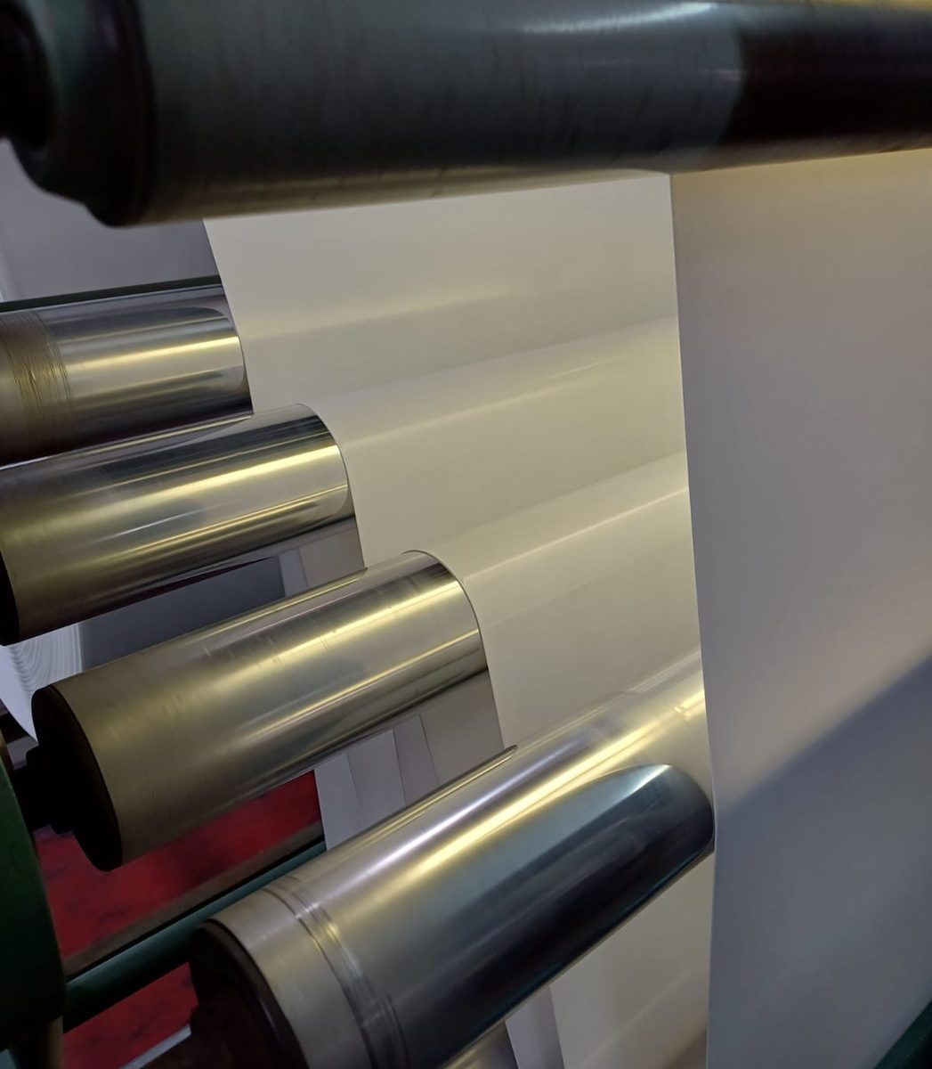 White flexible film running through rollers